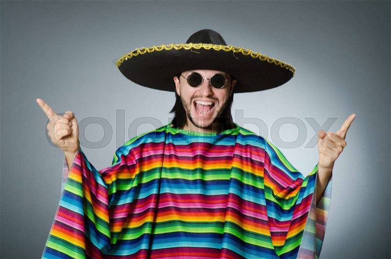 Man in a vivid mexican poncho gray background isolated, stock photo