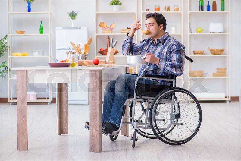 Disabled man preparing soup at kitchen, stock photo