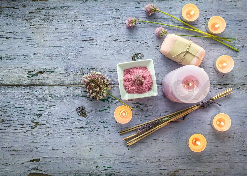 Scented candles of different sizes, smelly smoking sticks and wildflowers, homemade soap, weathered paint, topview, stock photo