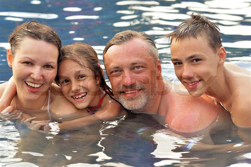 Happy family in a pool in summer, stock photo