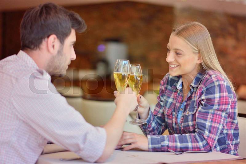 Happy young lovers celebrating their anniversary at restaurant, stock photo