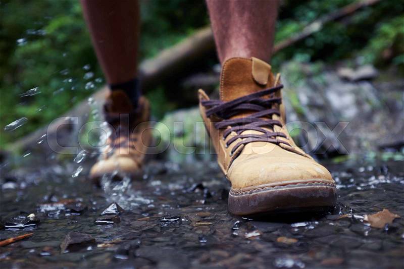 Close-up of males boots with splashing water , stock photo
