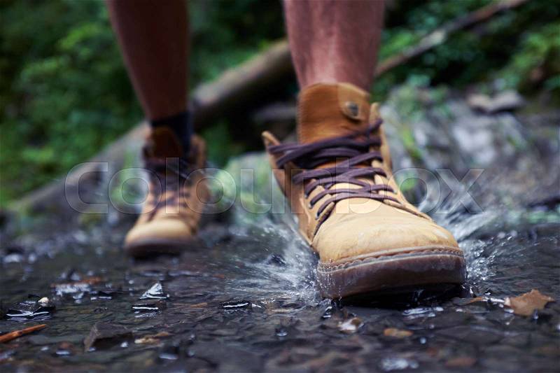 Close-up of males boots with splashing water , stock photo