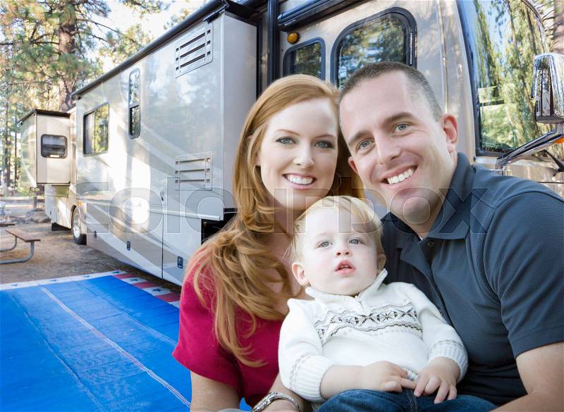 Happy Young Military Family In Front of Their Beautiful RV At The Campground, stock photo