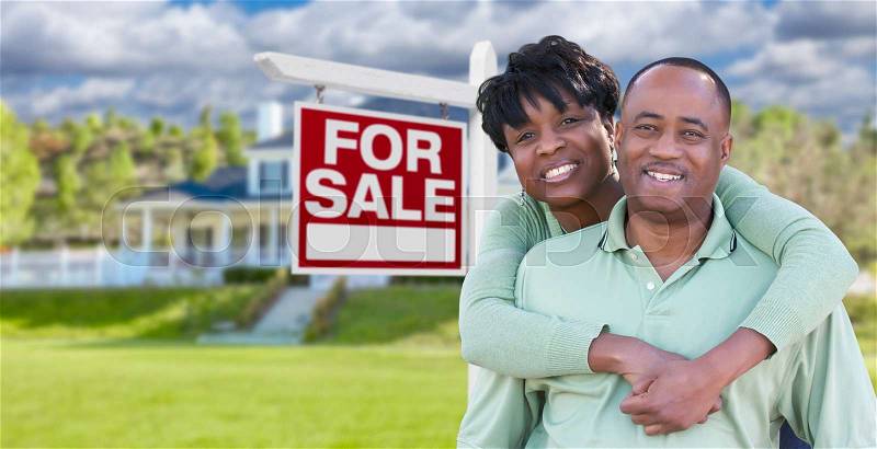 Happy African American Couple In Front of Beautiful House and For Sale Real Estate Sign, stock photo