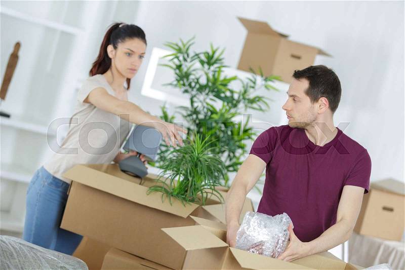 Couple moving in house sitting on the floor, stock photo