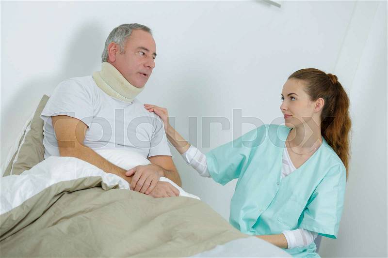 Beautiful female nurse and an old man at the hospital, stock photo