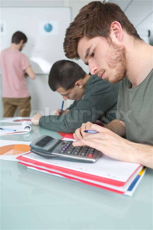 Students with notebook and calculator at school, stock photo