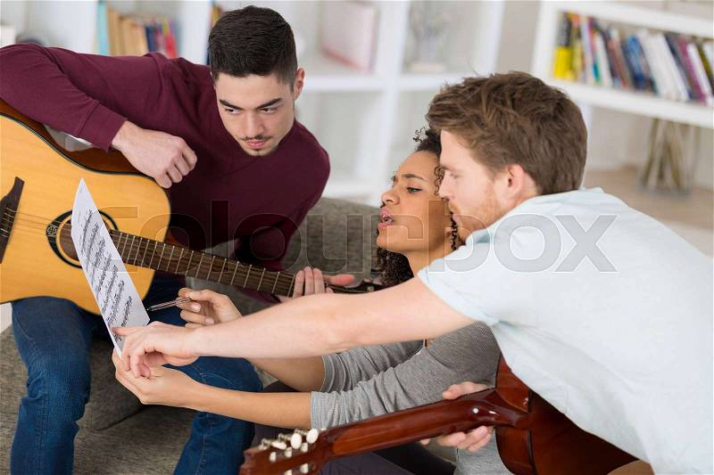 Friends playing guitars together, stock photo