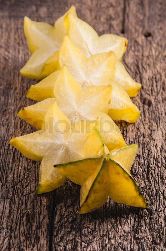 Yellow star fruit or star apple on wood background , stock photo
