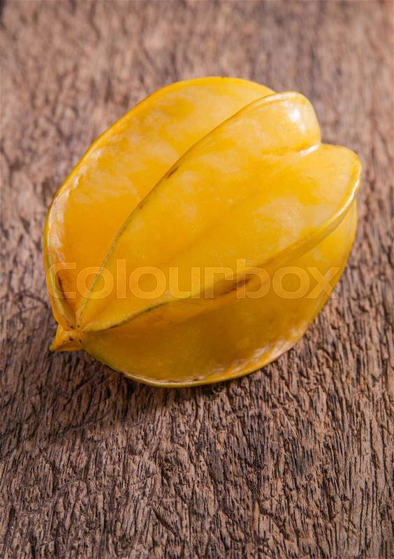 Yellow star fruit or star apple on wood background , stock photo
