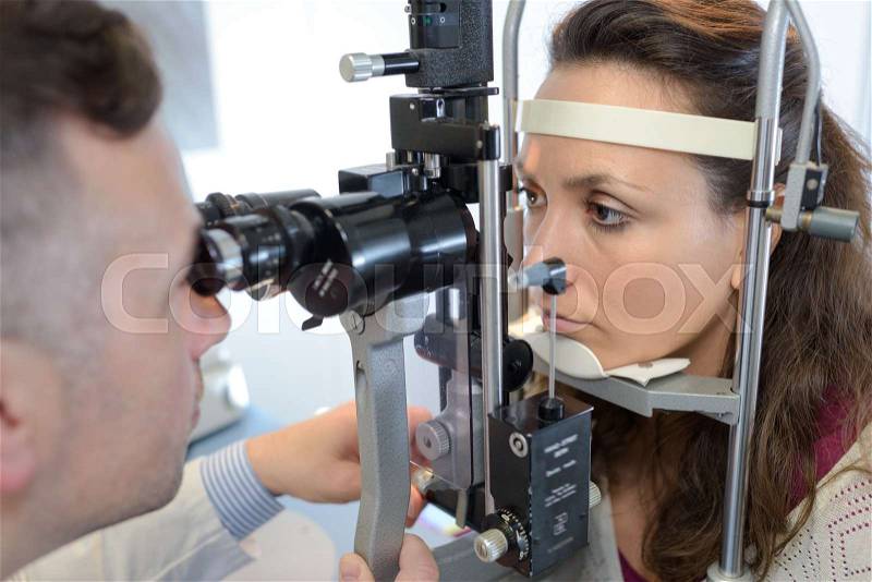Eye doctor druring a test with patient, stock photo