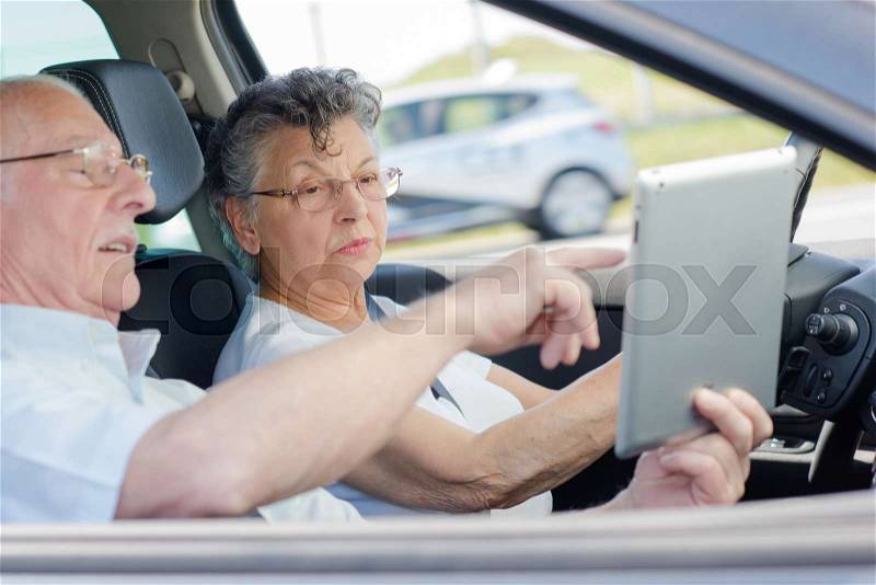 Old happy people enjoying a road trip in the car, stock photo