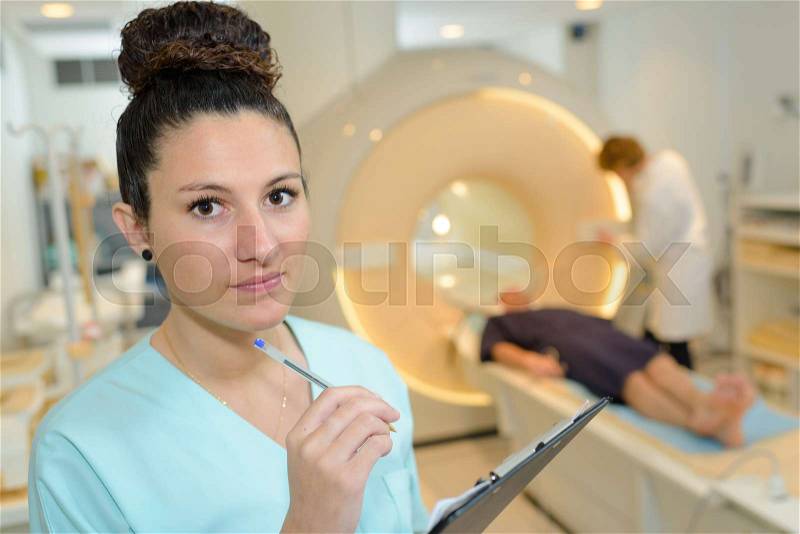 Female radiologist talking notes on clipboard, stock photo