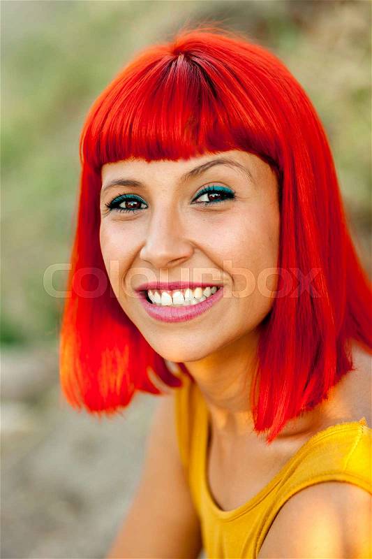 Happy red hair woman with yellow dress in a park, stock photo