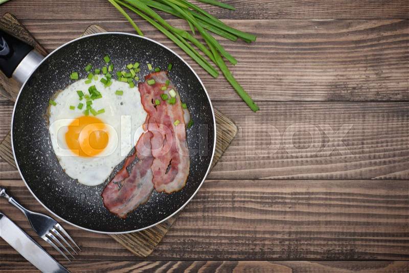 Bacon with sunny side up egg on pan top view, stock photo