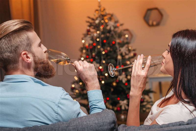 Happy young couple drinking champagne at new year party, stock photo