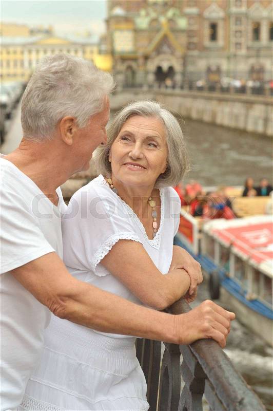 Loving cute senior couple traveling in city, stock photo