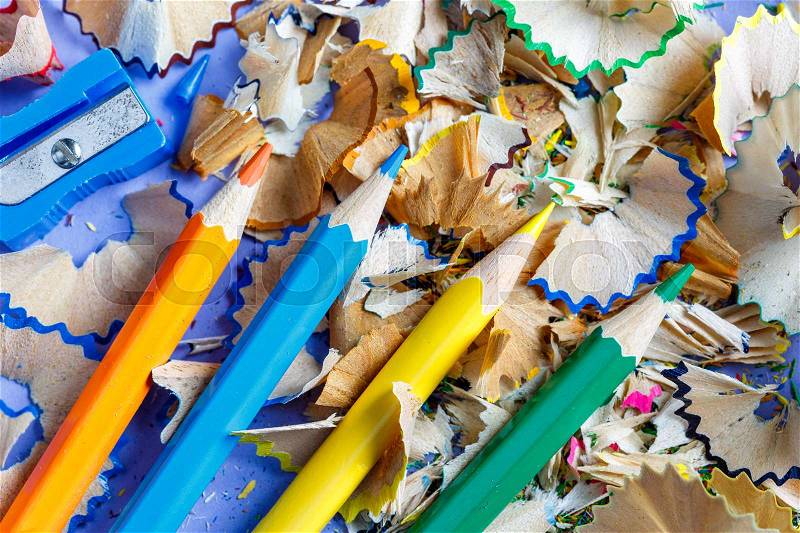 Sharpened colored pencils sharpener and pencil shavings, view from top, stock photo
