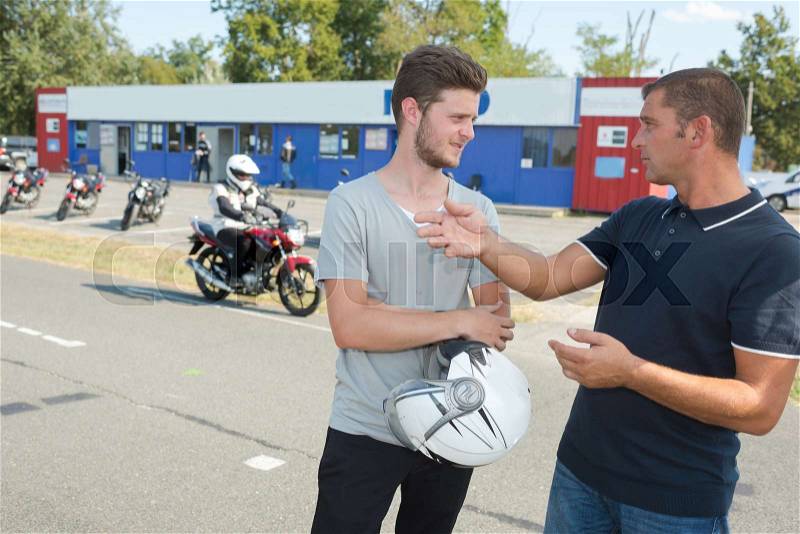 Young man taking driving test with instructor, stock photo