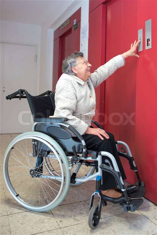 Old woman in a wheelchair using lift, stock photo