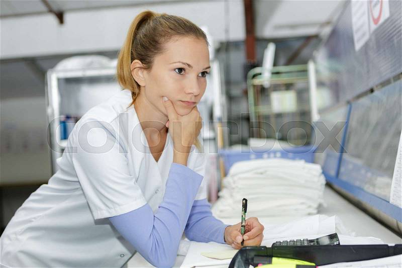 Laundry worker at the dry cleaners, stock photo
