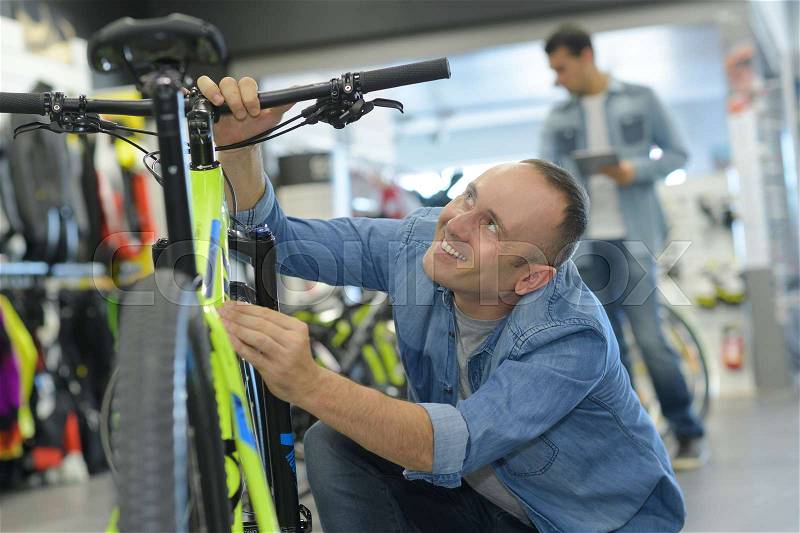 Man choosing a bike at bike shop, stock photo