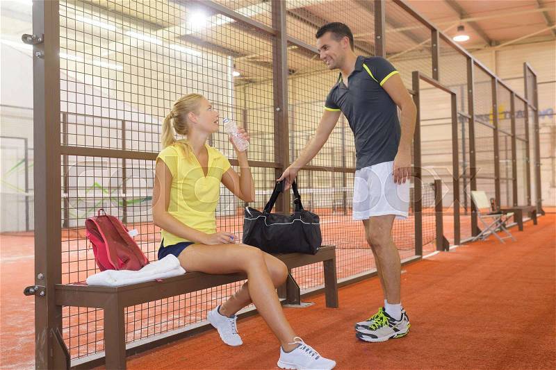 Sportsman and sportswoman resting after tennis training, stock photo
