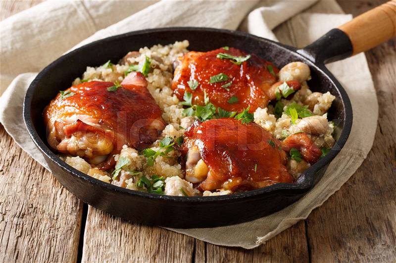 Baked chicken thighs with organic quinoa and mushrooms close up in a pan. horizontal , stock photo