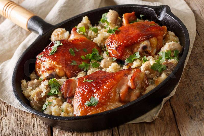 Natural Food: Baked chicken thighs with quinoa and mushrooms close up in a pan. horizontal , stock photo