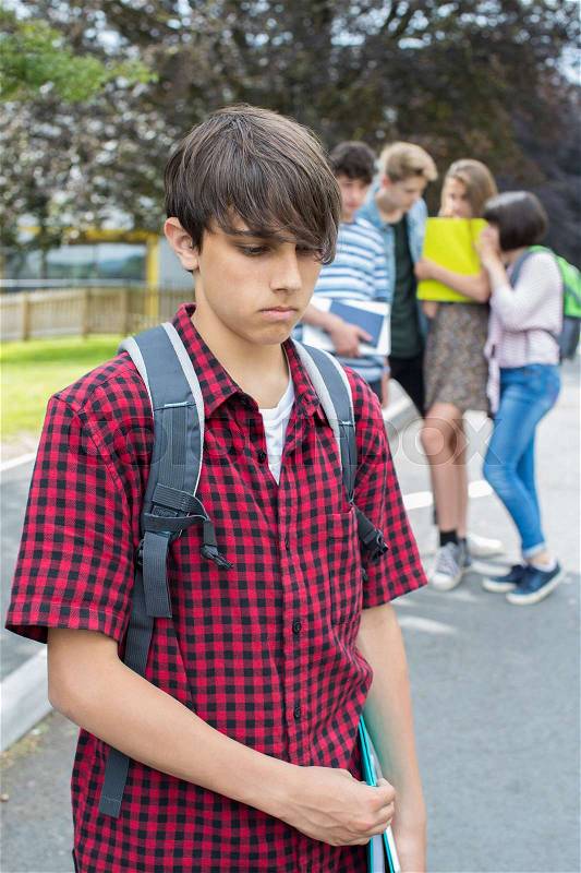 Unhappy Boy Being Gossiped About By School Friends, stock photo