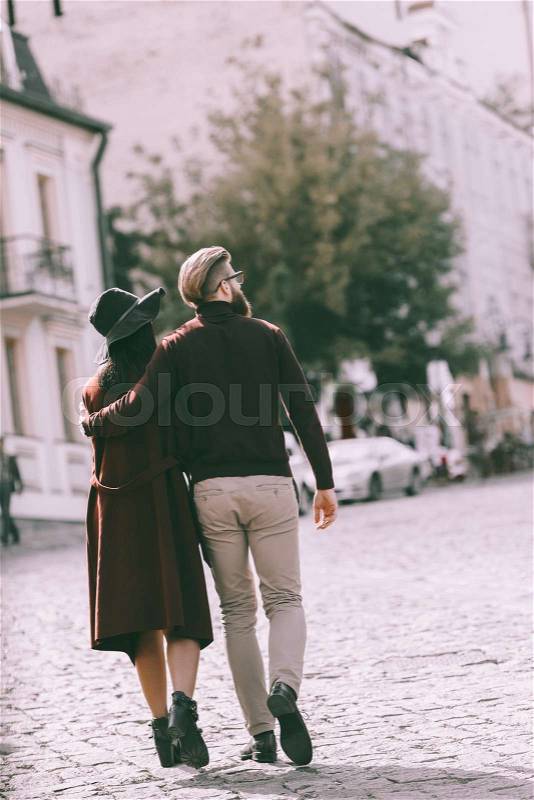 Back view of fashionable couple walking at old european city, stock photo