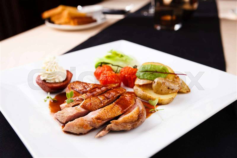 Roasted duck with pear, marinated in red wine and mascarpone rose, stock photo