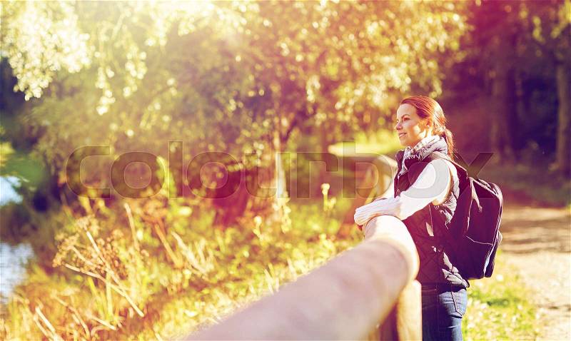 Travel, tourism, hike and people concept - happy woman with backpack outdoors, stock photo