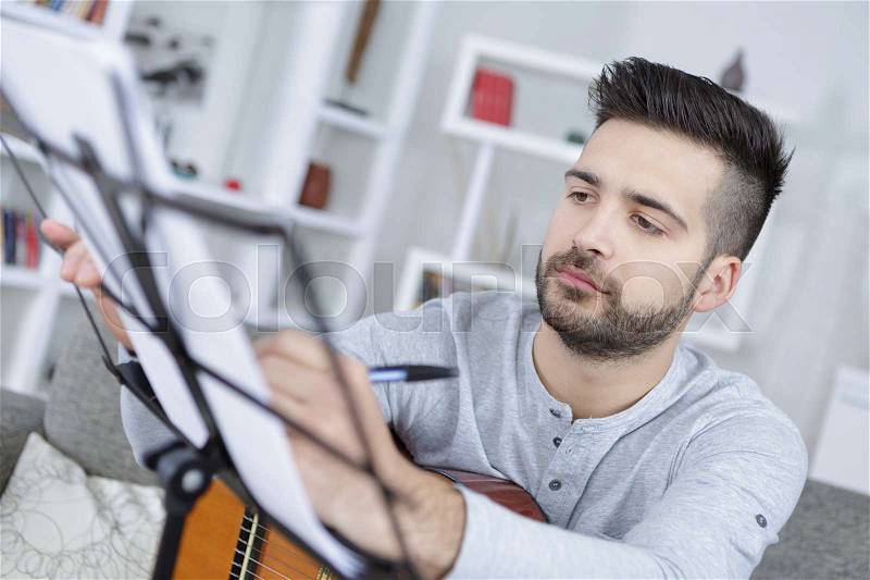 Coustic guitar player rehearses his new song, stock photo