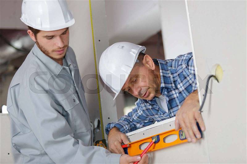 Builders checking work with spirit level, stock photo