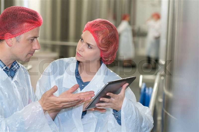 Two factory workers discussion with tablet pc, stock photo