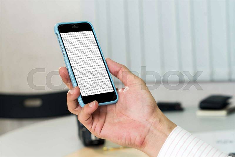Mock up and close up image of businessman\'s hand holding smartphone with blank grid lines on white screen , stock photo