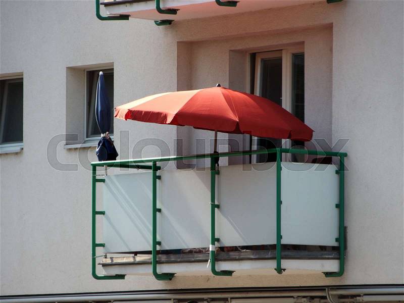 Single Red Parasol on Glass Balcony in Apartment Building, stock photo