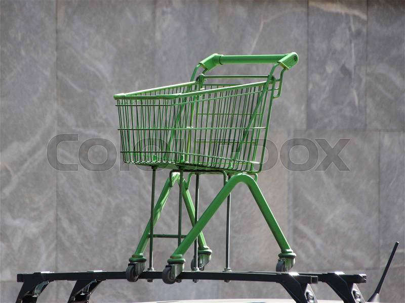 Green Shopping Trolley Isolated Mounted on Car Rooftop, stock photo