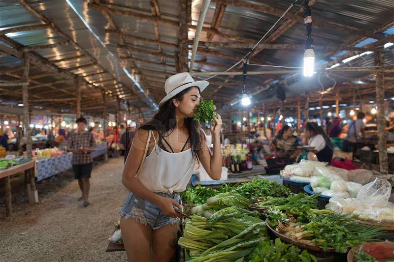 Young Woman Smell Herbs Choosing Green Potherbs On Market Girl Shopping On Traditional Street Bazaar, stock photo