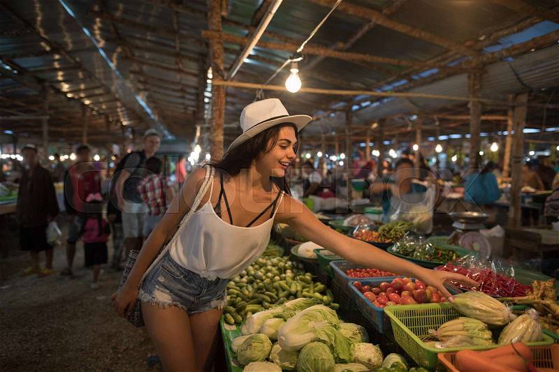 Young Woman Choosing Vegetables On Market Girl Shopping On Traditional Street Bazaar, stock photo