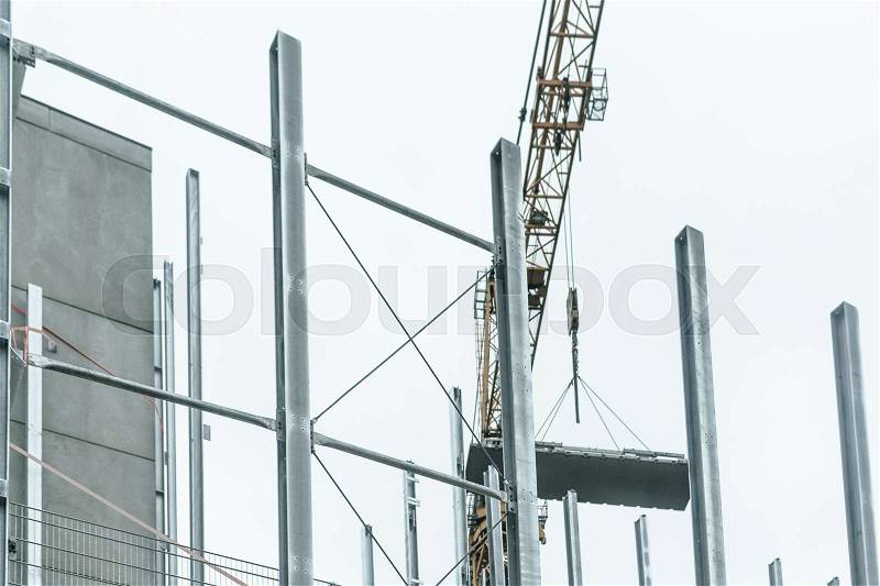Generic construction site background with scaffolding on the building and crane, stock photo