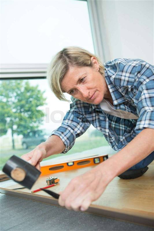 Woman putting together self assembly furniture assemble flat pack, stock photo