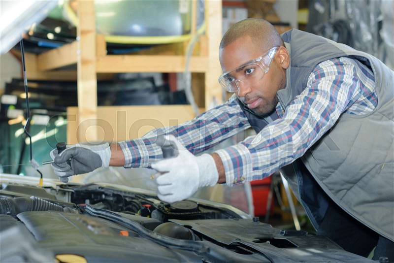 Young happy mechanic at work, stock photo