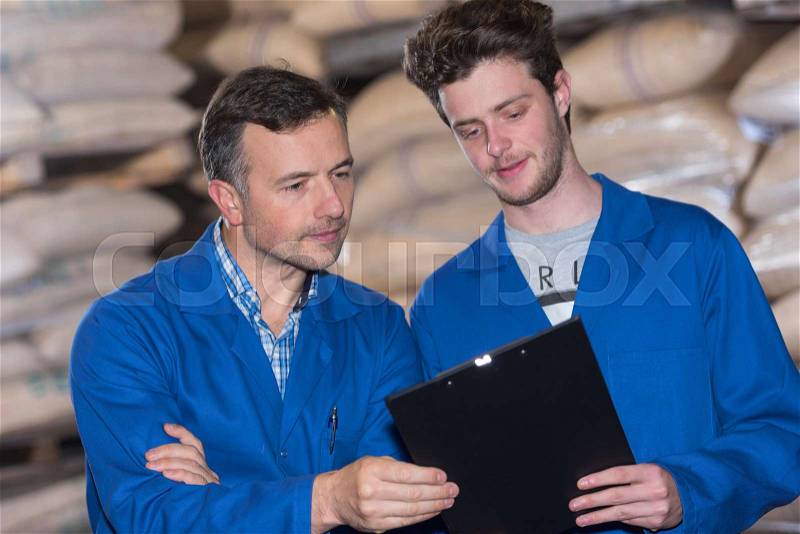 Two warehouse workers doing stock take, stock photo