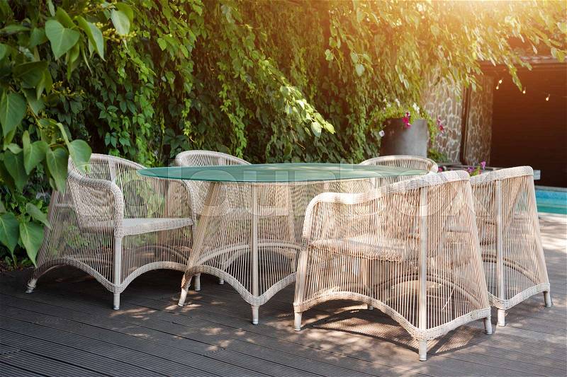 Wicker armchairs and table, modern garden furniture. Cozy space for relax in the garden, stock photo