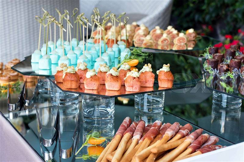 Appetizers, finger food, party food, sliders. Canape, tapas. Served table at summer terrace cafe. Catering service. Outdoor restaurant table with food, stock photo
