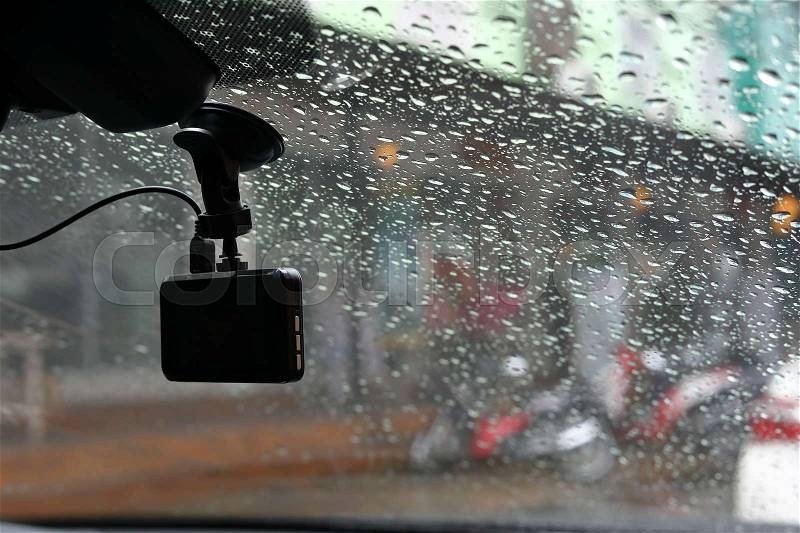 Small video camera record inside motor vehicle on windshield, drive car road trips in rainny day weather, stock photo