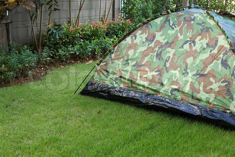 Tent camping wild camouflage style, design of backyard in green grass garden field, stock photo